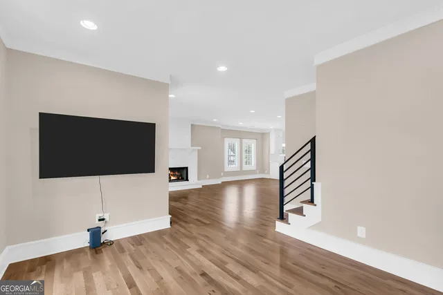 a view of a livingroom with wooden floor and a flat screen tv