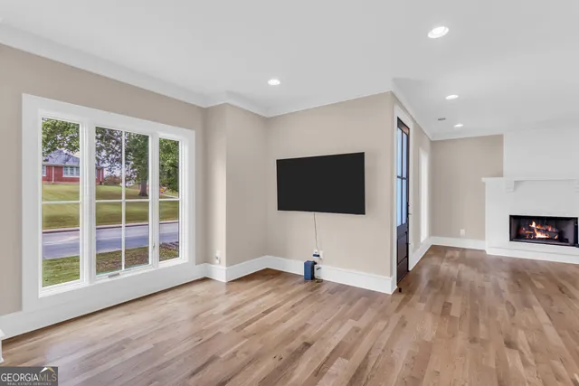 a view of a livingroom with wooden floor and a fireplace