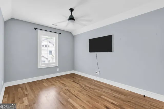 a view of a livingroom with wooden floor and a flat screen tv