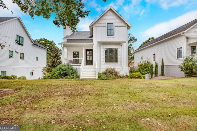 a front view of house with yard and trees around