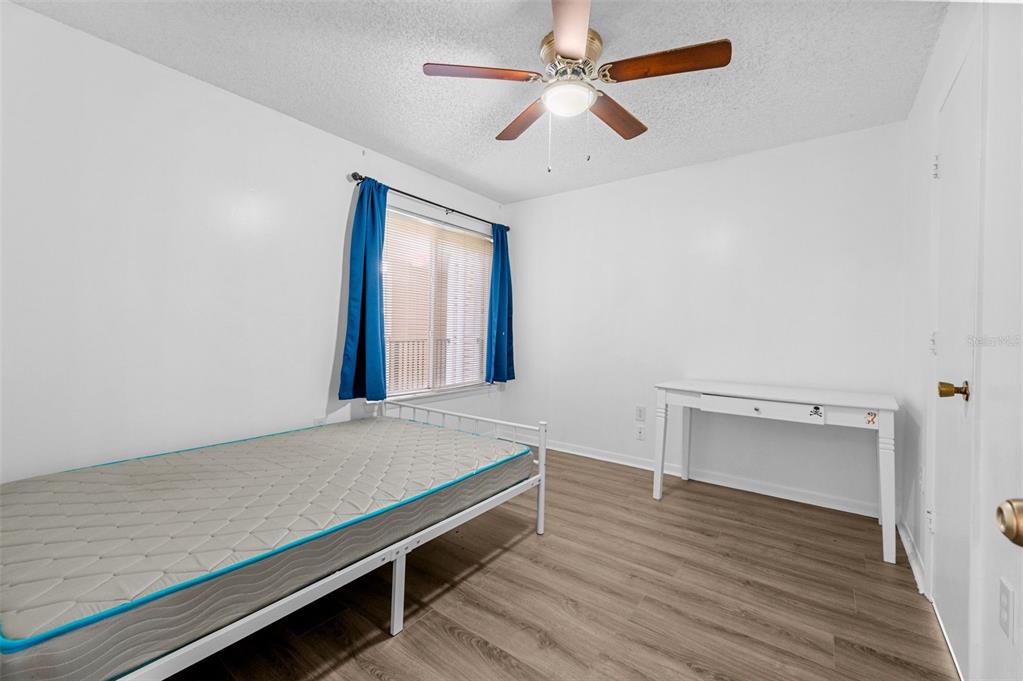 3921 Southwest 34th Street, Unit 208 Gainesville, FL 32608 - Photo 10 of 33 an empty room with wooden floor and ceiling fan