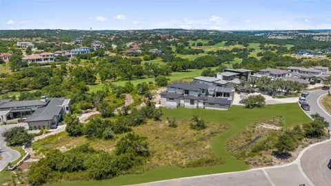 an aerial view of residential houses with outdoor space and trees