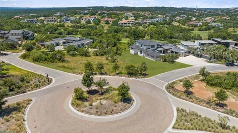 an aerial view of a house with a yard and lake view