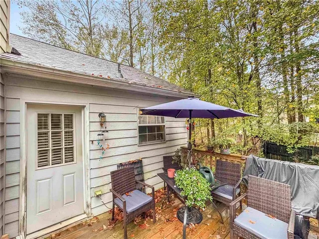 a view of a patio with a table and chairs under an umbrella