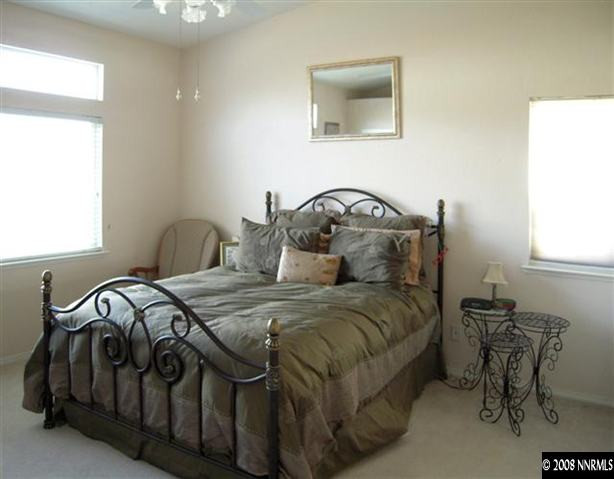9788 Thunder Mountain Way Reno, NV 89521 - Photo 4 of 5 a bedroom with a bed and a table in it