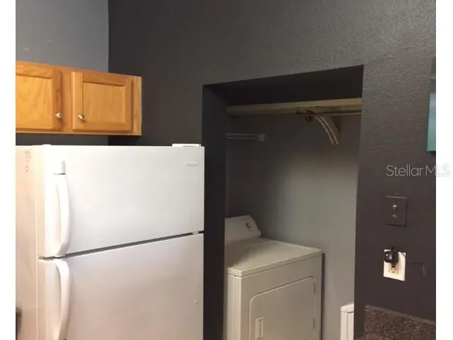 a white refrigerator freezer and a stove sitting inside of a kitchen