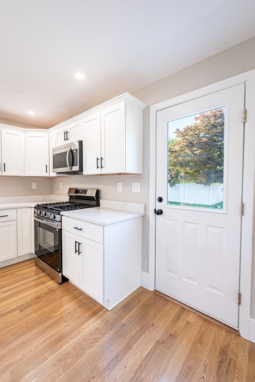 17 Hamlet Street Fairhaven, MA 02719 - Photo 11 of 40 a kitchen with stainless steel appliances a white stove top oven cabinets and a wooden floor