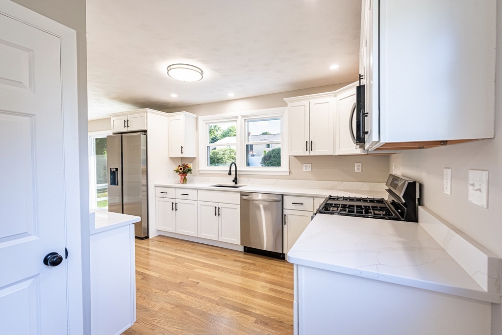 17 Hamlet Street Fairhaven, MA 02719 - Photo 13 of 40 a kitchen with a sink a stove a refrigerator and white cabinets