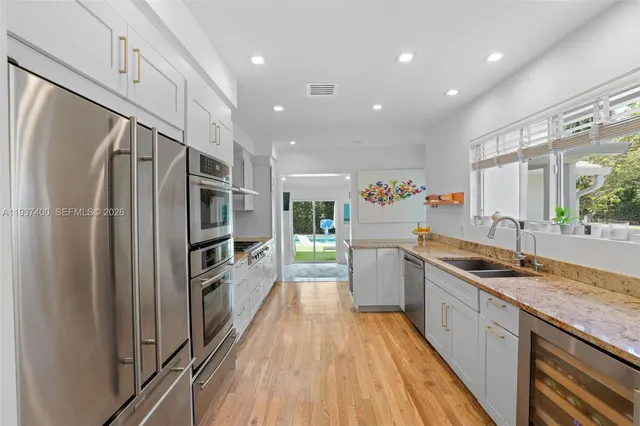 a kitchen with granite countertop a refrigerator and a sink