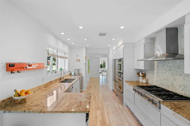 a kitchen with stainless steel appliances granite countertop a stove and a sink