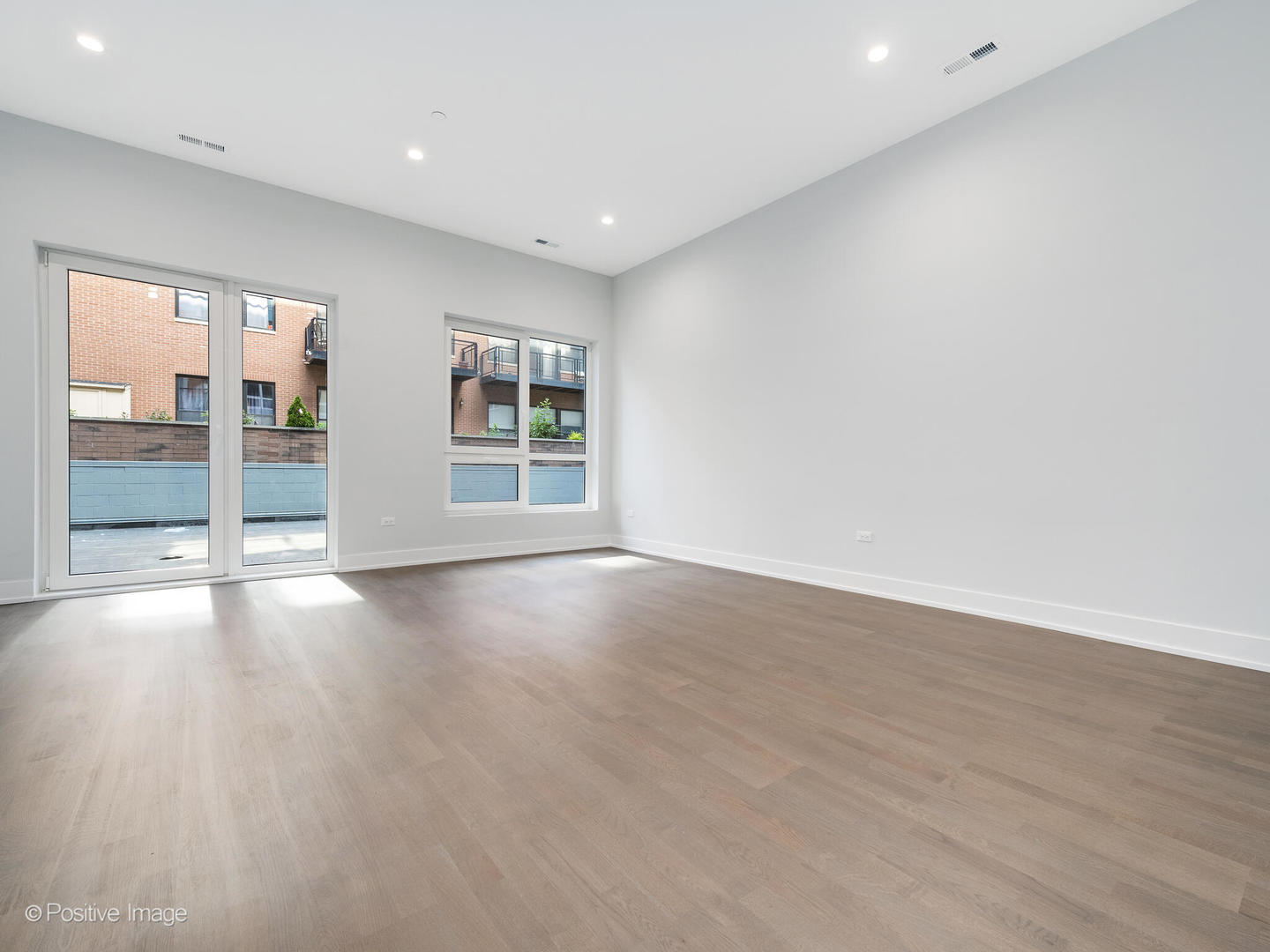 2139 West Madison Street, Unit 201 Chicago, IL 60612 - Photo 5 of 11 an empty room with wooden floor and windows