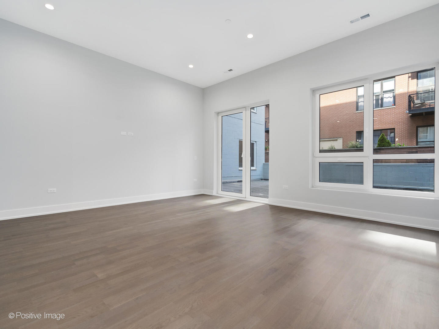 2139 West Madison Street, Unit 201 Chicago, IL 60612 - Photo 6 of 11 an empty room with wooden floor and windows