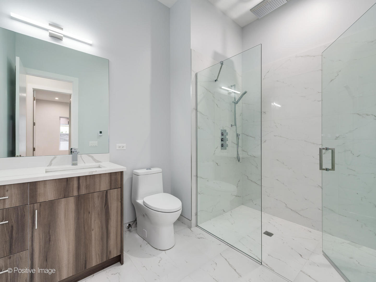 2139 West Madison Street, Unit 201 Chicago, IL 60612 - Photo 10 of 11 a bathroom with a shower sink vanity and toilet