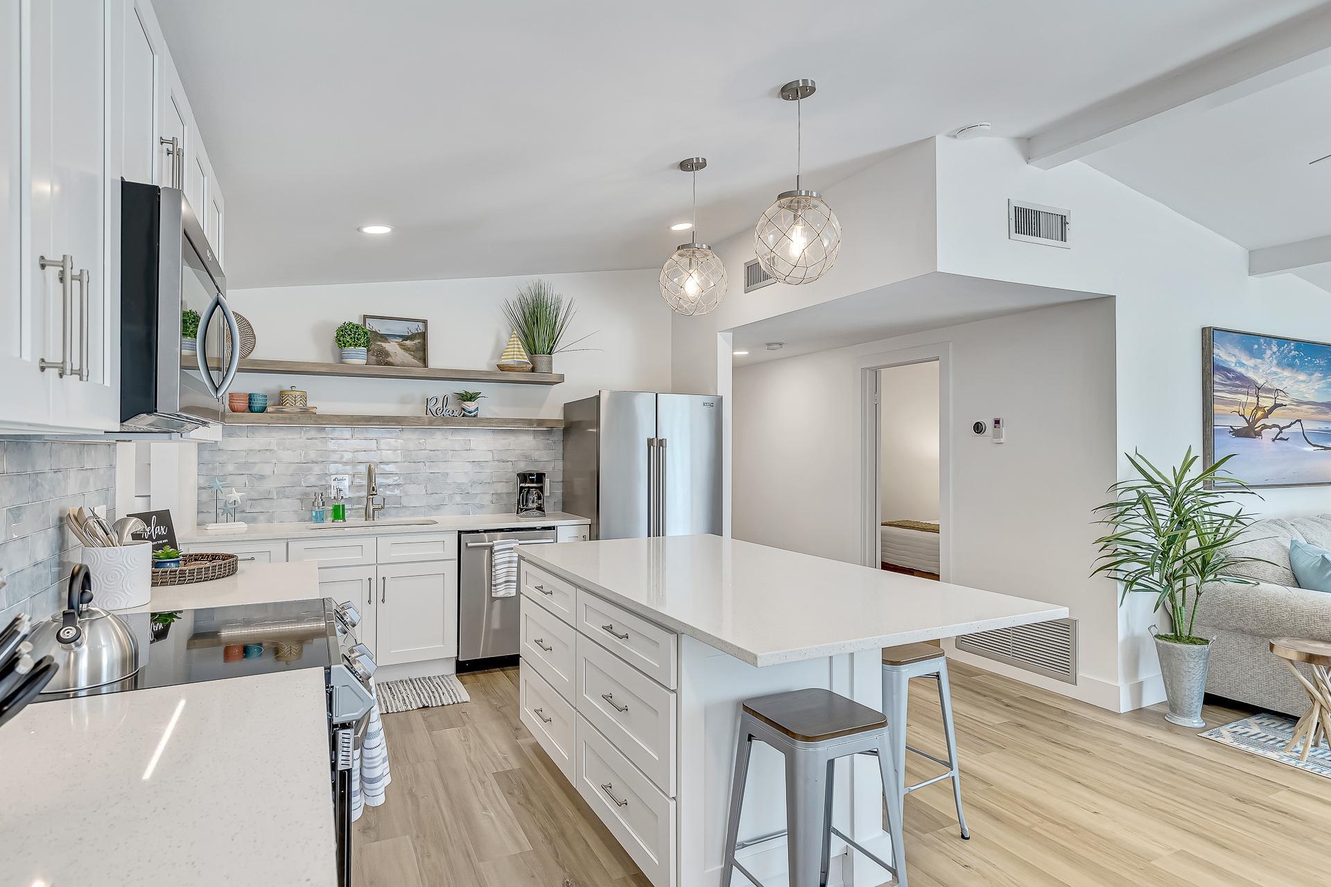 110 Terrapin Road St. Augustine, FL 32086 - Photo 10 of 46 a large kitchen with kitchen island white cabinets and stainless steel appliances