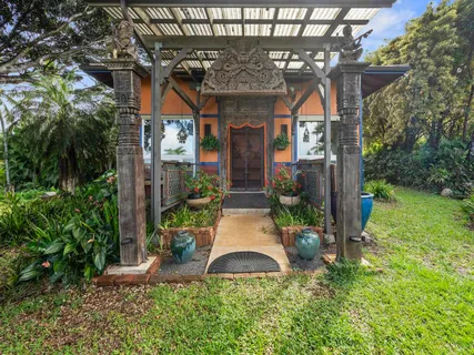 front view of a house with a small yard and potted plants