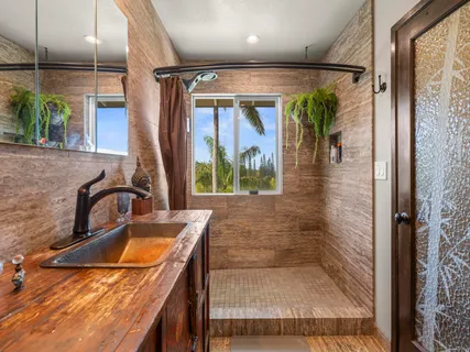 a bathroom with a granite countertop sink a mirror and shower