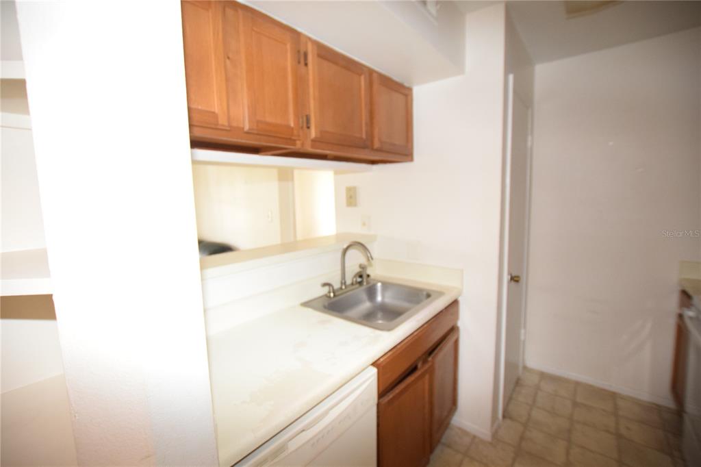 4659 Cason Cove Drive, Unit 3022 Orlando, FL 32811 - Photo 16 of 29 a kitchen with a sink and cabinets