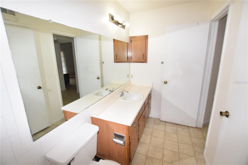 4659 Cason Cove Drive, Unit 3022 Orlando, FL 32811 - Photo 25 of 29 a bathroom with a sink a toilet and mirror