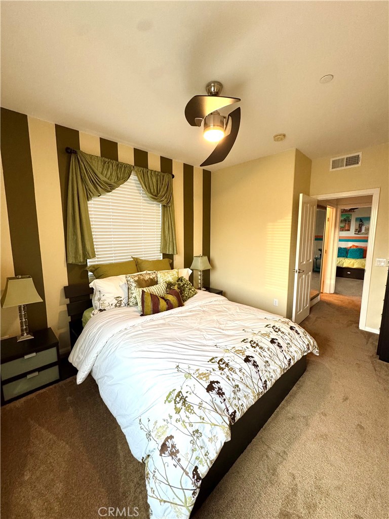 7666 Papyrus Place, Unit 2 Rancho Cucamonga, CA 91739 - Photo 15 of 23 a bedroom with a bed and a large mirror
