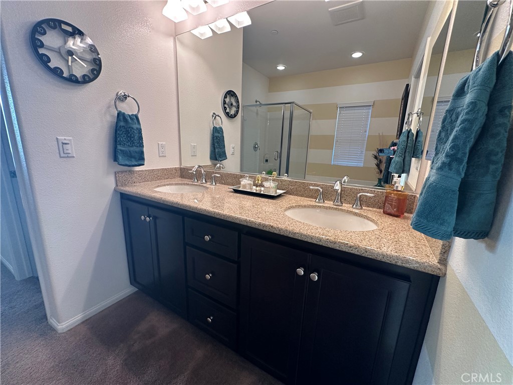 7666 Papyrus Place, Unit 2 Rancho Cucamonga, CA 91739 - Photo 18 of 23 a bathroom with a double vanity sink and a mirror