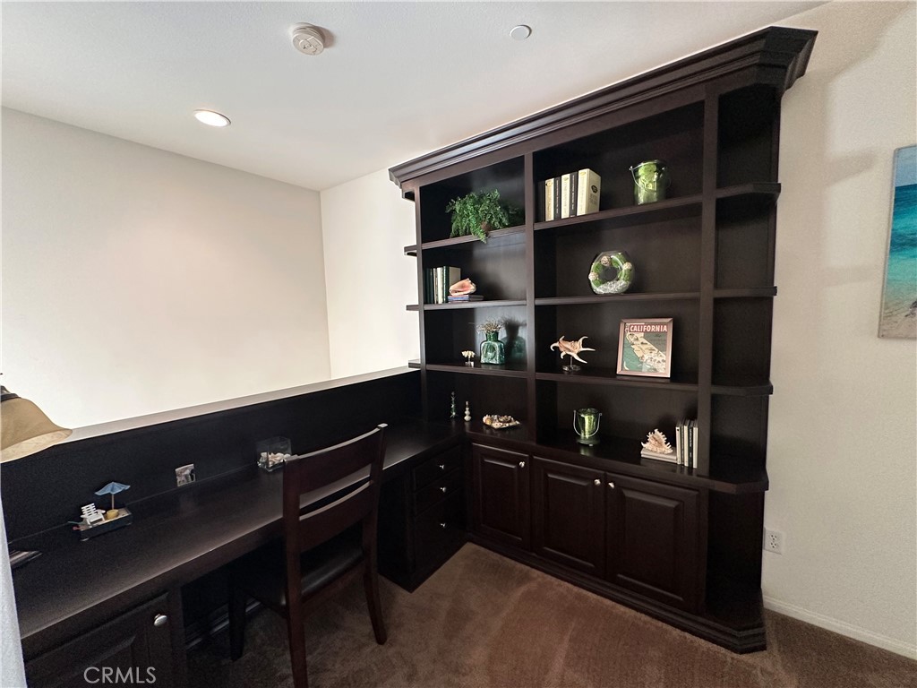 7666 Papyrus Place, Unit 2 Rancho Cucamonga, CA 91739 - Photo 7 of 23 a living room with a bookshelf and a book shelf