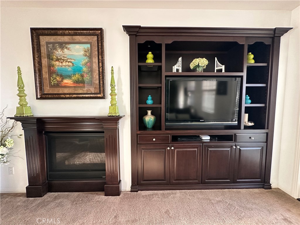 7666 Papyrus Place, Unit 2 Rancho Cucamonga, CA 91739 - Photo 9 of 23 a living room with fireplace and a flat screen tv