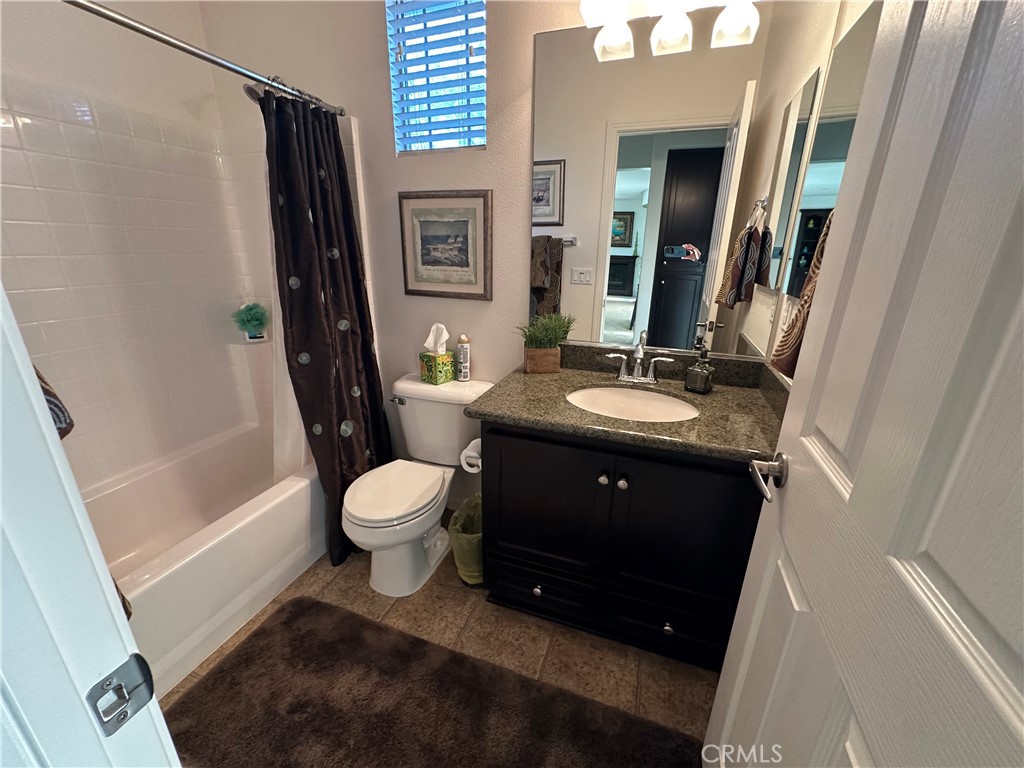 7666 Papyrus Place, Unit 2 Rancho Cucamonga, CA 91739 - Photo 10 of 23 a bathroom with a granite countertop sink toilet a shower a mirror and a sink