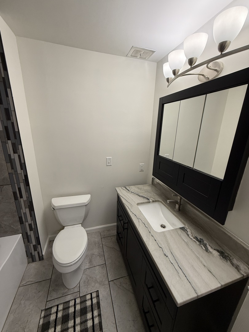 185 Jacqueline Street Morris, IL 60450 - Photo 11 of 19 a bathroom with a toilet a sink and mirror