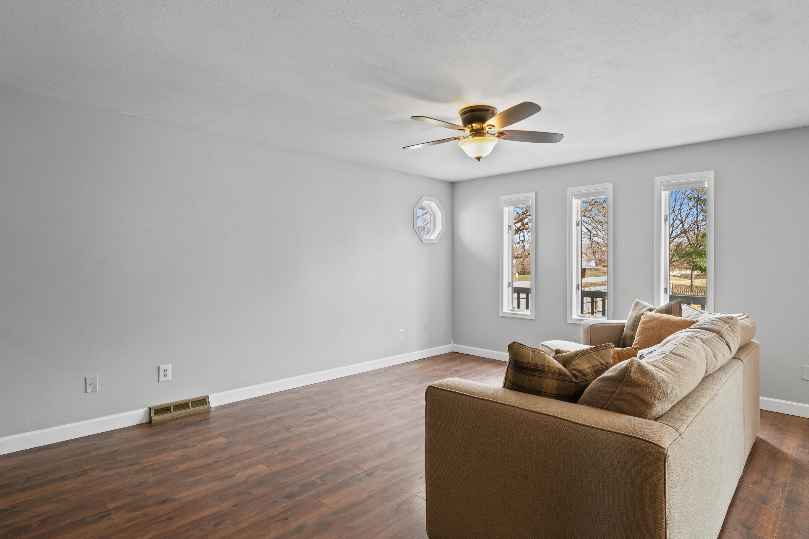 2212 Borg Road Delavan, WI 53115 - Photo 10 of 43 Living room featuring ceiling fan, octagonal accent window, and three windows with outdoor views