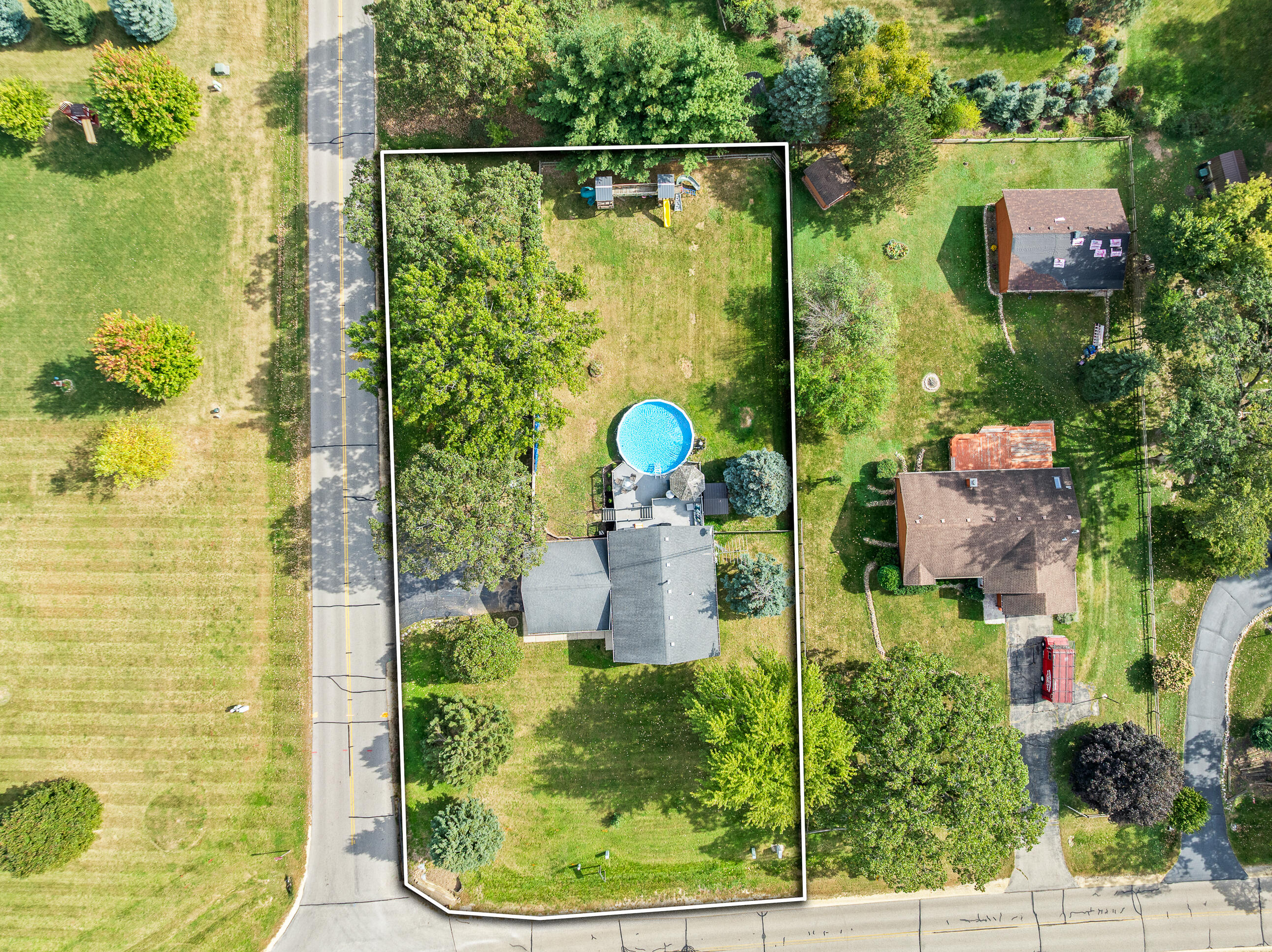 2212 Borg Road Delavan, WI 53115 - Photo 14 of 15 Aerial view of the full property showing the home, pool, deck, gazebo, and generous lot surrounded by mature tree canopy.
