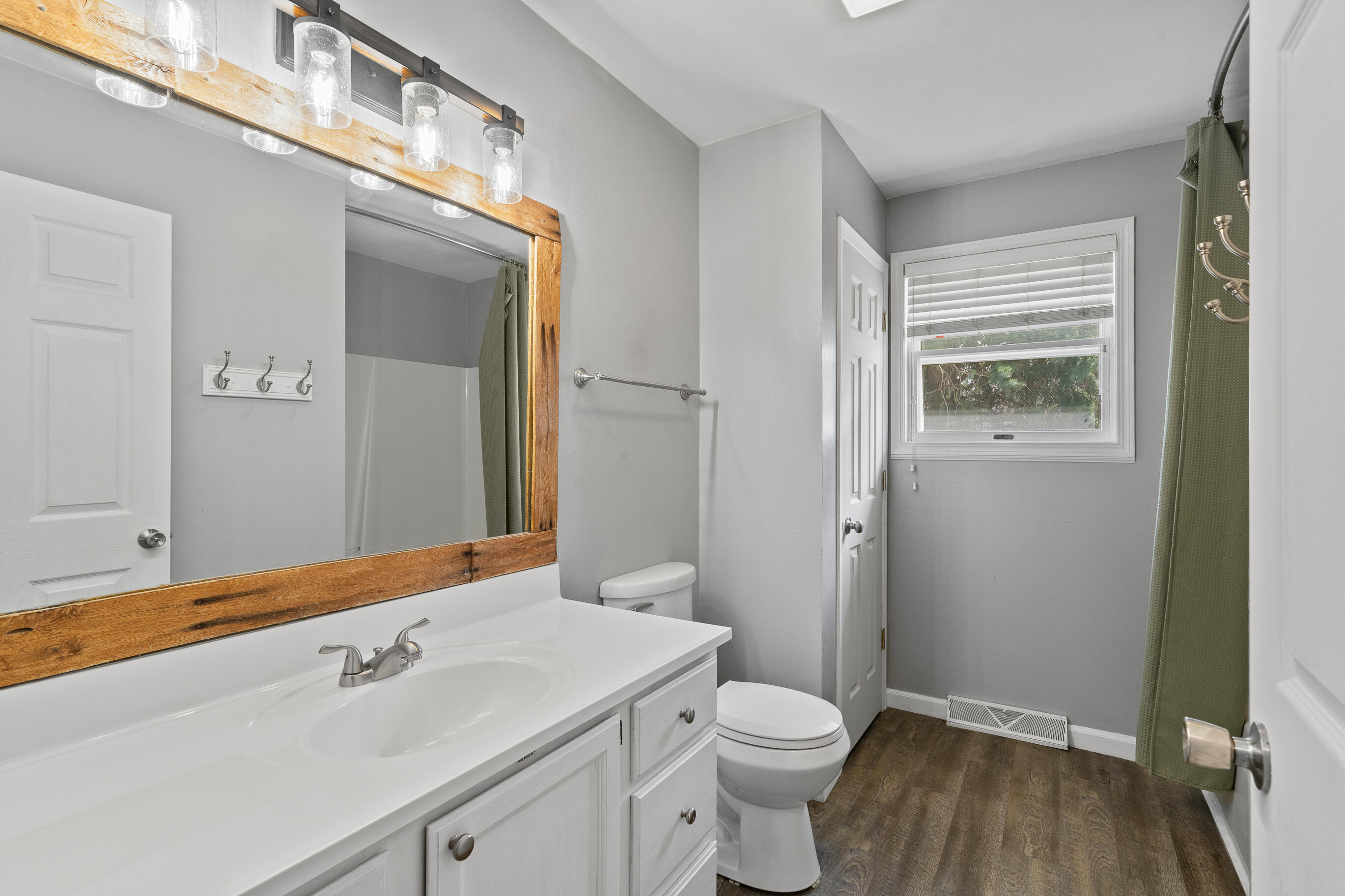 2212 Borg Road Delavan, WI 53115 - Photo 23 of 43 Main level full bathroom with white vanity, rustic wood-framed mirror, and mason jar-style light fixture