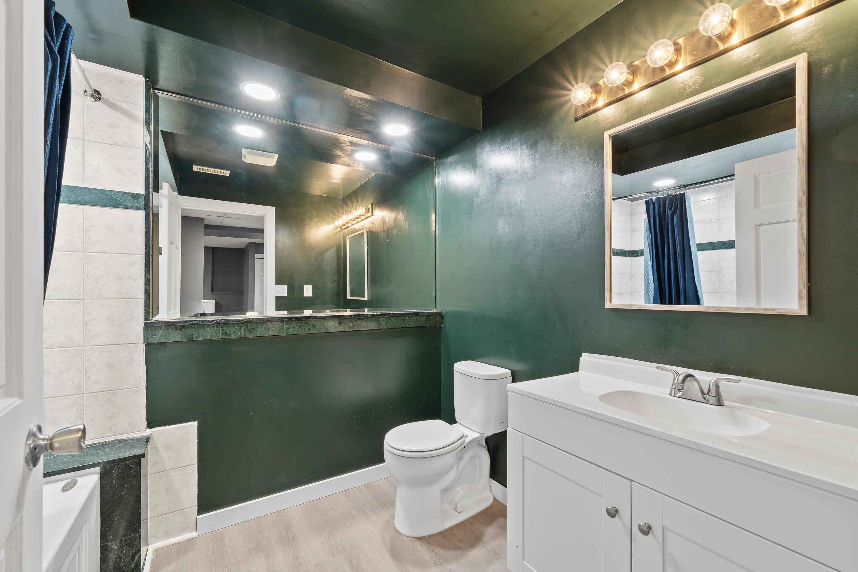 2212 Borg Road Delavan, WI 53115 - Photo 32 of 43 Lower level full bathroom with deep green walls, tile surround tub/shower with jetted tub, and white vanity