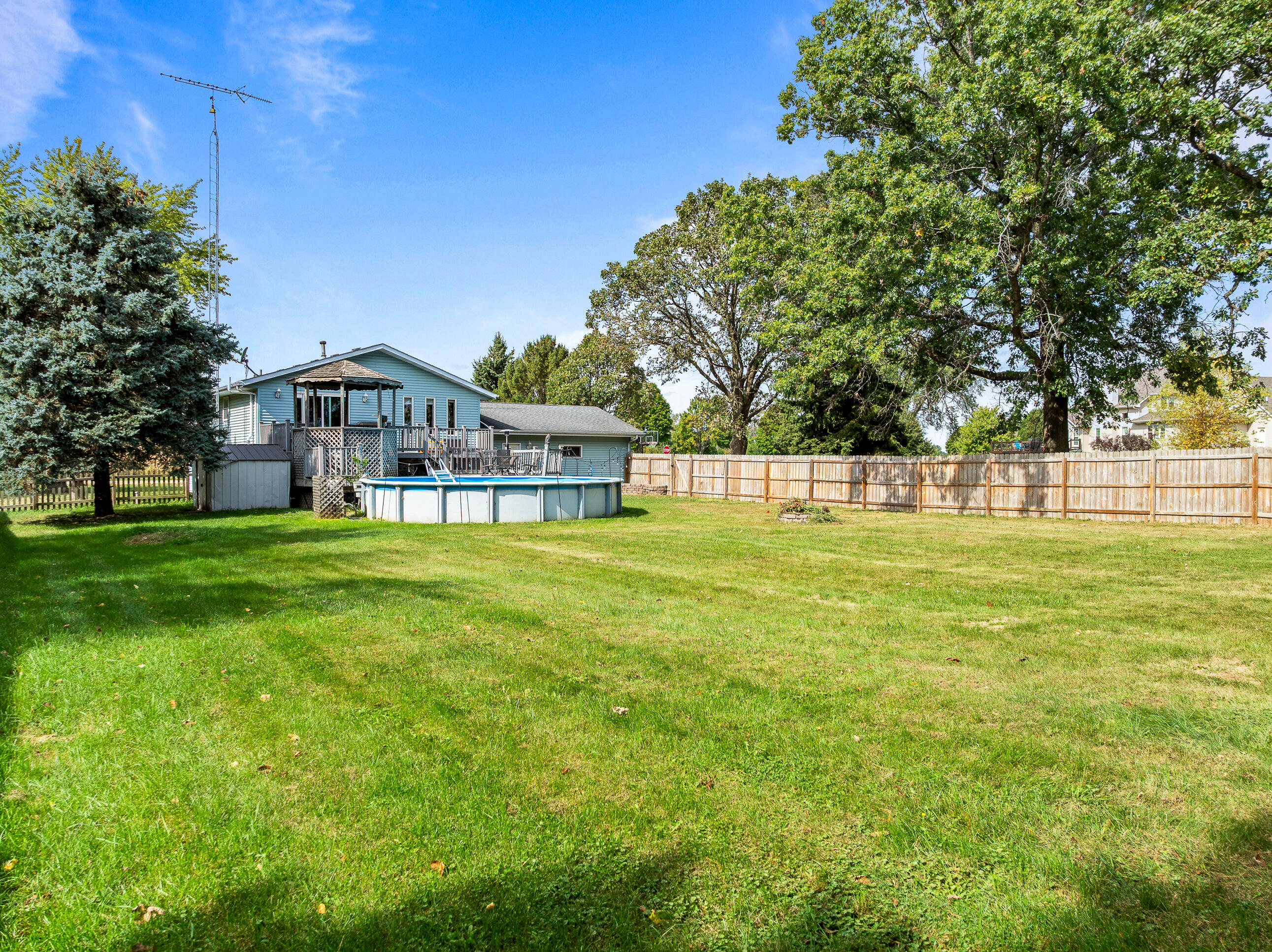 2212 Borg Road Delavan, WI 53115 - Photo 36 of 43 Spacious rear yard view showing the full depth of the lot, rear deck, pool, and privacy fence. Room for everyone to spread out.