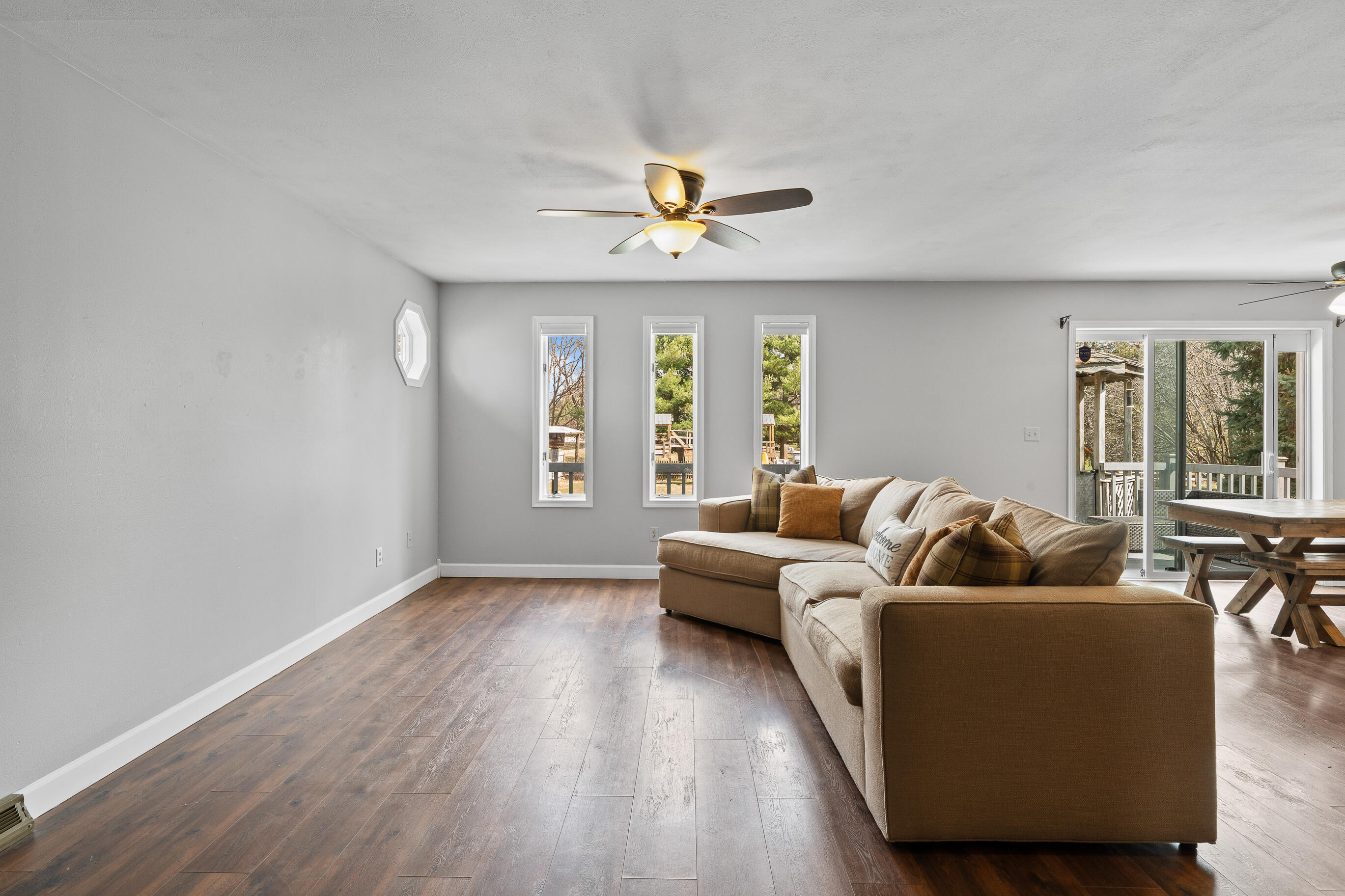 2212 Borg Road Delavan, WI 53115 - Photo 9 of 43 Living room with ceiling fan, three windows with natural light, and sliding glass door access to the deck