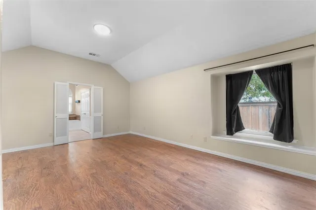 a view of a room with wooden floor and a window