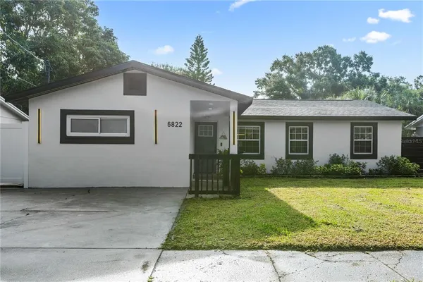 a view of a house with back yard and a garden
