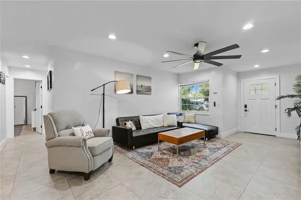 a living room with furniture and a ceiling fan