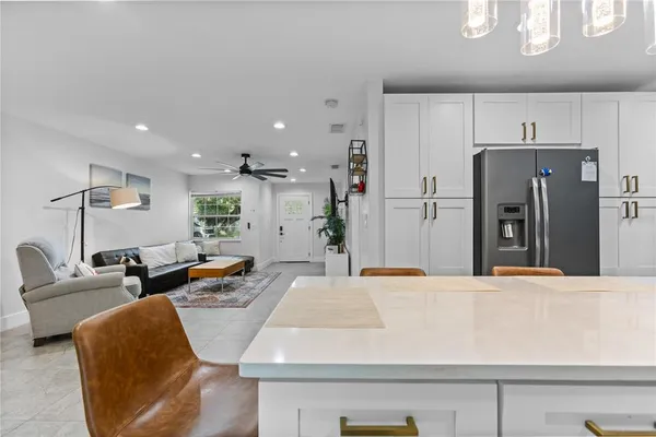 a large kitchen with stainless steel appliances kitchen island granite countertop a refrigerator and a couch