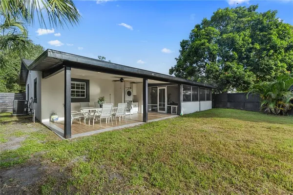 a view of a house with backyard and sitting area