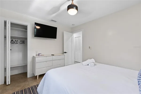 a bedroom with a bed and a flat screen tv