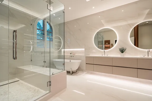 a bathroom with a double vanity sink mirror and shower