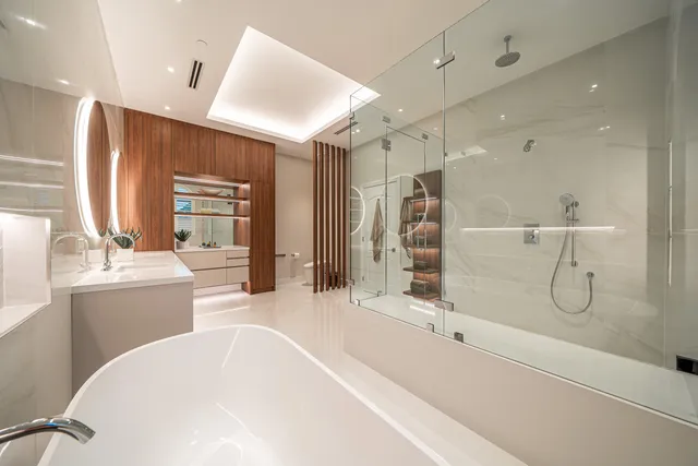 a bathroom with a tub sink shower and mirror