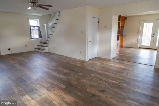 an empty room with wooden floor and a window
