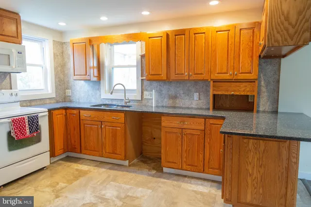 a view of a kitchen with granite countertop a sink and cabinets