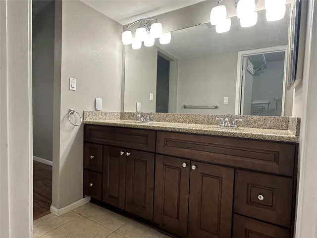 a bathroom with a granite countertop sink and a mirror