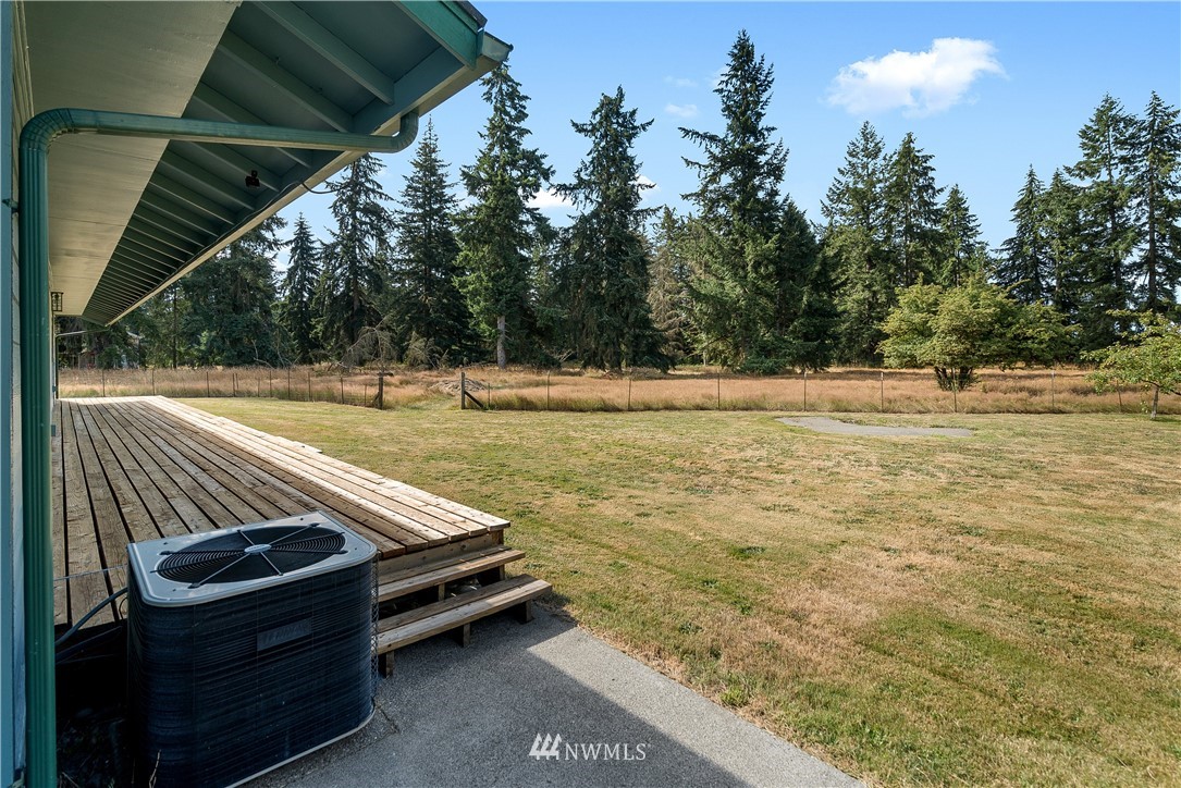7625 187th Avenue Southwest Rochester, WA 98579 - Photo 28 of 38 a view of a backyard with lawn chairs under an umbrella