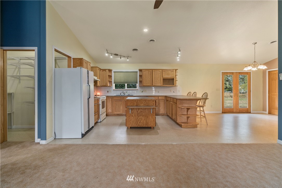 7625 187th Avenue Southwest Rochester, WA 98579 - Photo 6 of 38 a kitchen with stainless steel appliances kitchen island granite countertop a refrigerator and a stove top oven