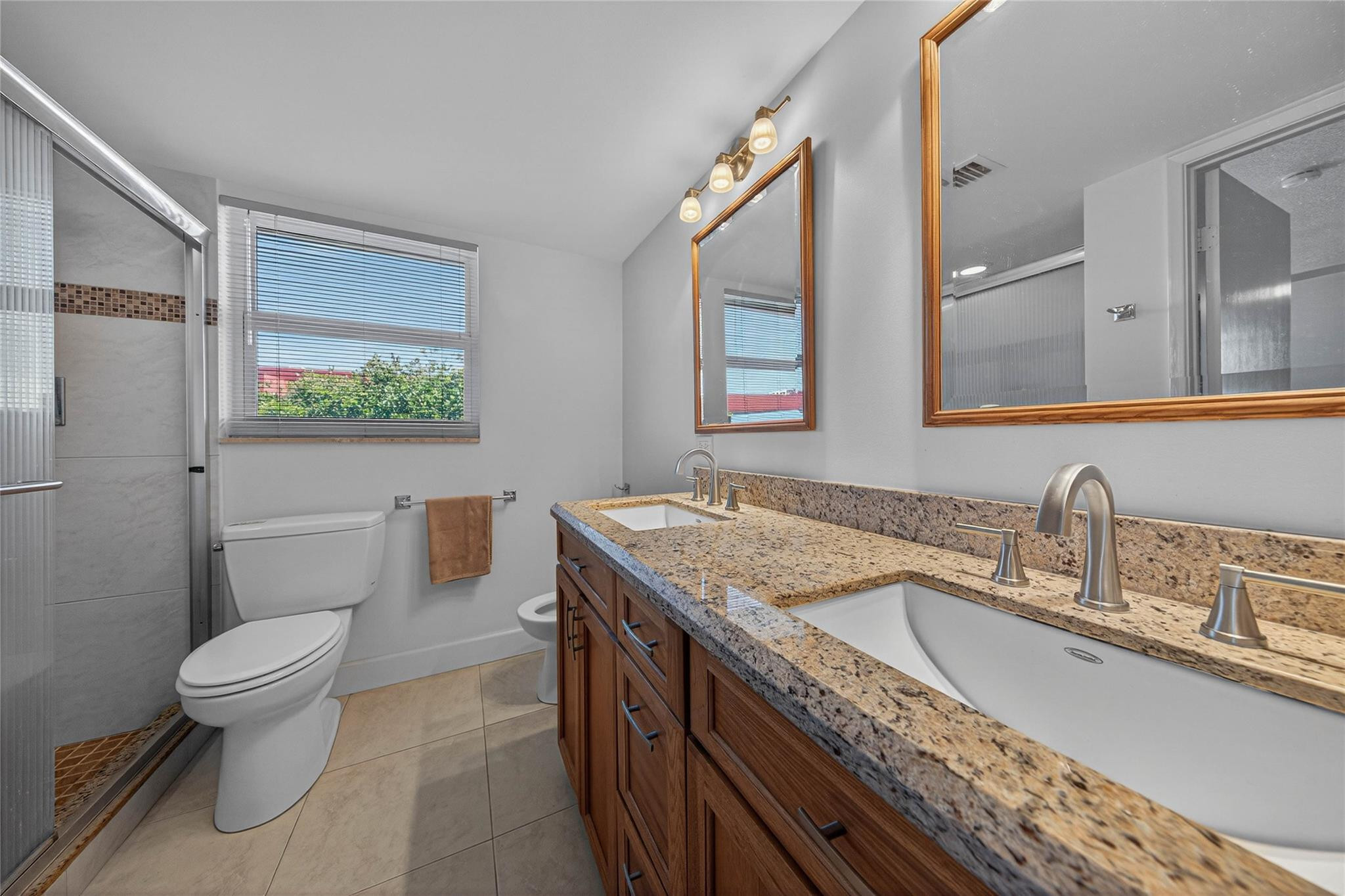 3150 Northeast 48th Court, Unit 414 Lighthouse Point, FL 33064 - Photo 18 of 33 a bathroom with a granite countertop sink a toilet and a mirror