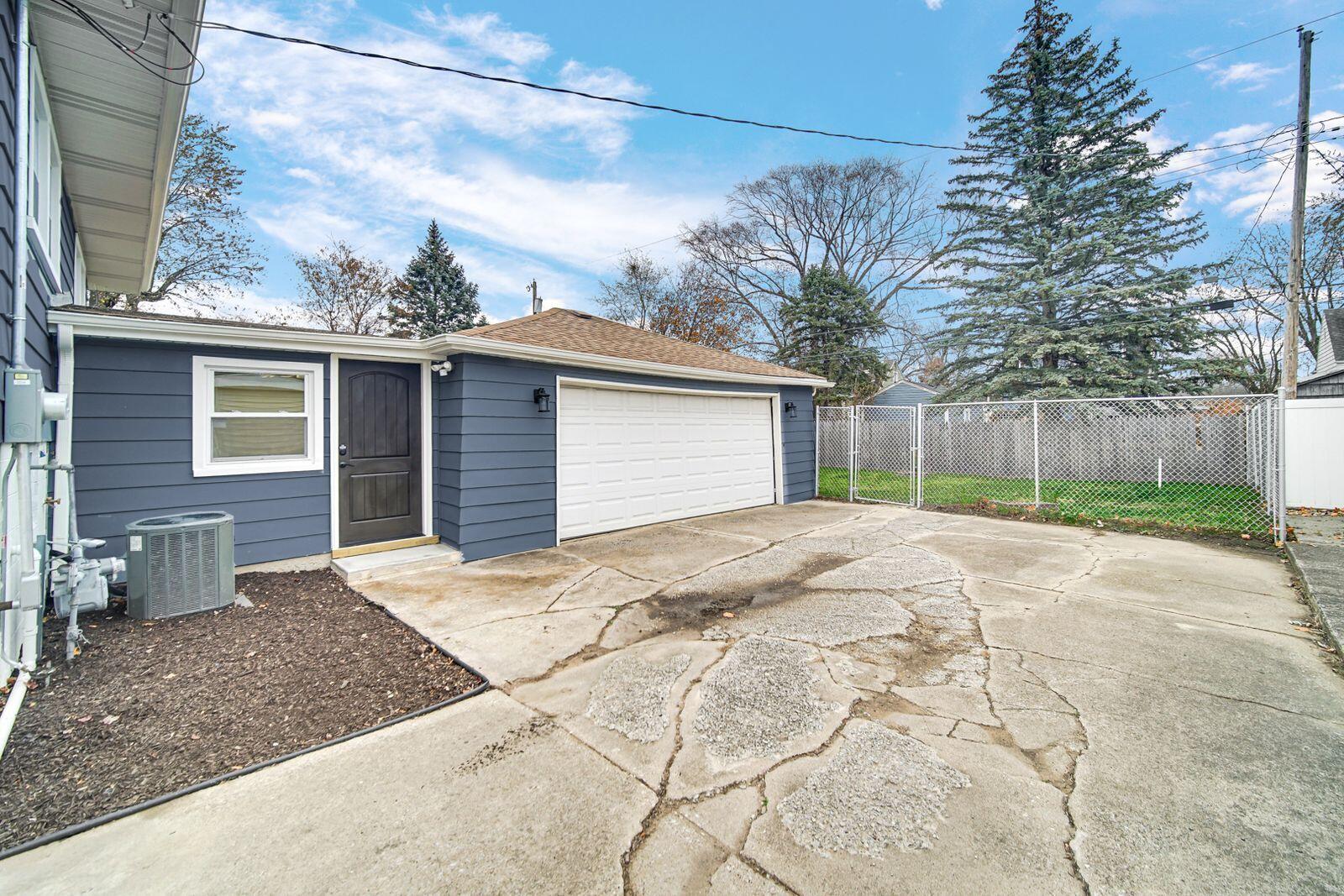7405 South McCook Avenue Hammond, IN 46323 - Photo 26 of 28 a front view of a house with a yard and garage