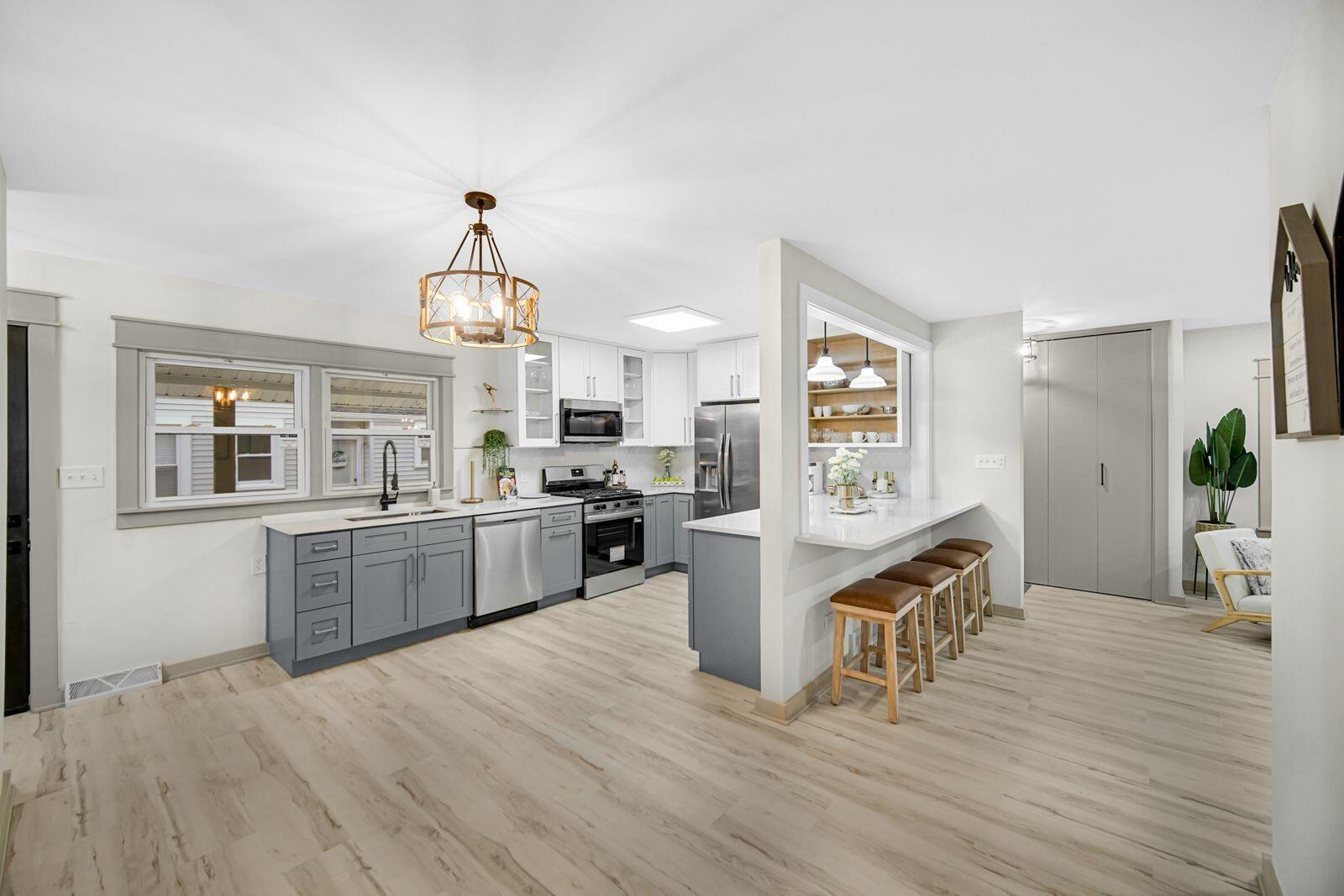 7405 South McCook Avenue Hammond, IN 46323 - Photo 5 of 28 a kitchen with granite countertop wooden floors and stainless steel appliances
